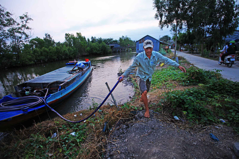 Nước ngọt sinh hoạt được vận chuyển bằng ghe thuyền đến bán cho các hộ dân vùng xâm nhập mặn. (Ảnh: Trọng Đạt/TTXVN)