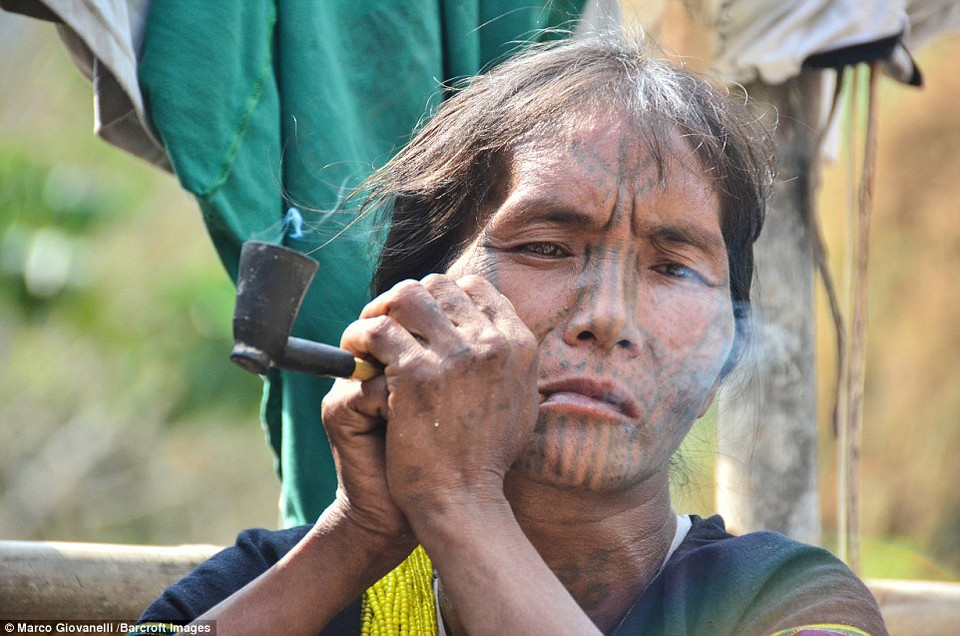 Phụ nữ dân tộc Munn xăm hình tròn nhỏ hoặc bán nguyệt từ cằm tới cổ. (Nguồn: Dailymail)