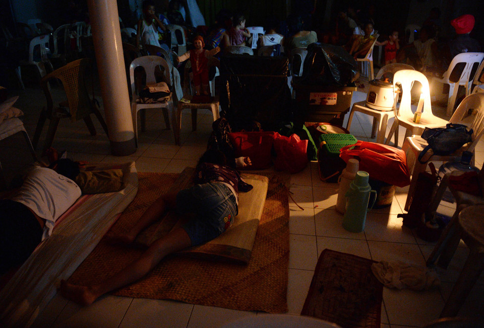 Người dân trú tránh bão trong một tu viện dước ánh sáng của những ngọn nến tại thành phố Legazpi.