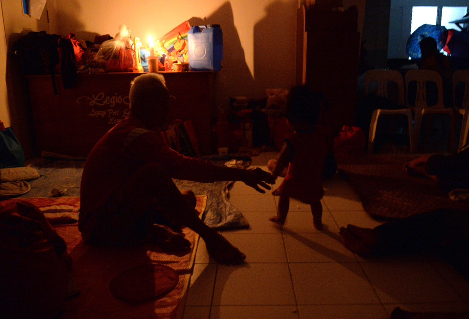  Người dân trú tránh bão trong một tu viện dước ánh sáng của những ngọn nến tại thành phố Legazpi.