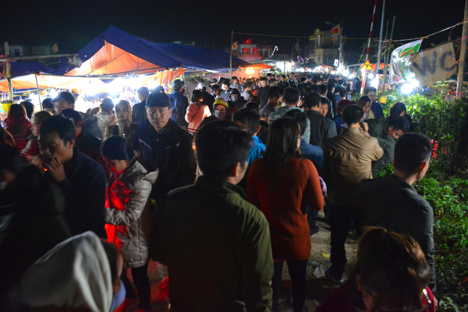 Càng về đêm dòng người đến với phiên chợ mua may bán rủi ngày càng đông. (Ảnh Công Luật/TTXVN)