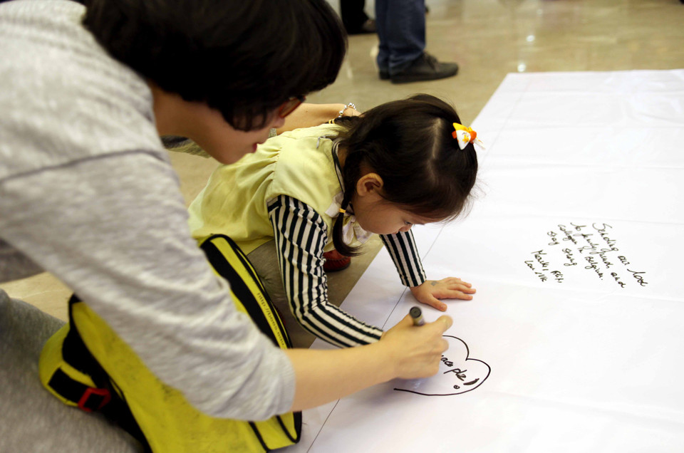 Xúc động ghi lại những dòng chữ tưởng niệm. (Ảnh: Doãn Đức/Vietnam+)