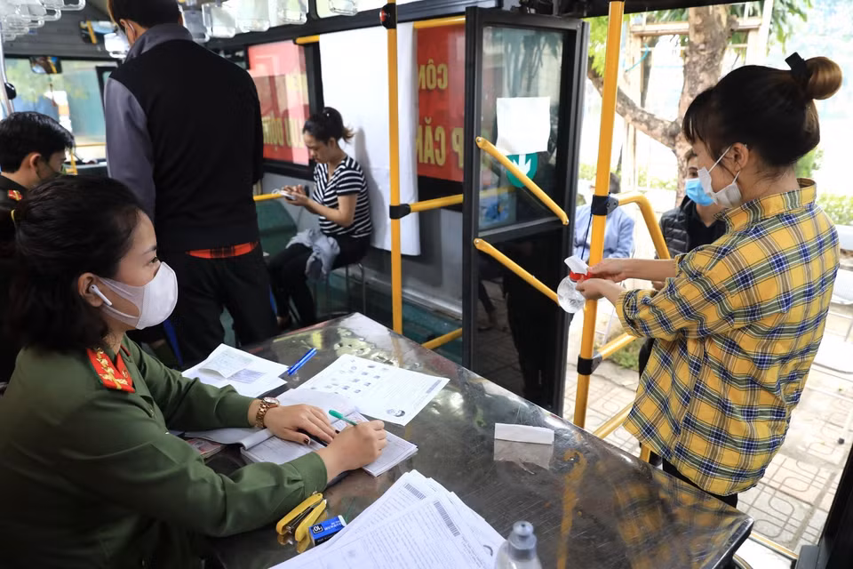 Mỗi công dân khi lên xe buýt làm thủ tục đều thực hiện rửa tay xịt khử khuẩn đảm bảo phòng chống dịch. (Ảnh: Thành Đạt/TTXVN)