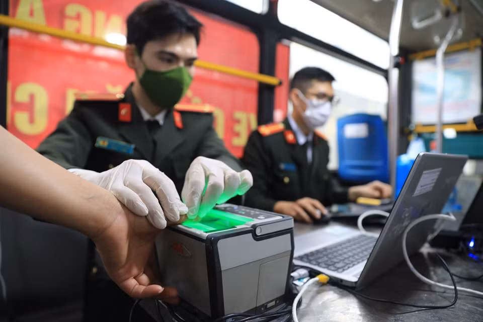 Các công đoạn lấy dấu vân tay điện tử, chụp ảnh thẻ được thực hiện ngay trong xe buýt lưu động. (Ảnh: Thành Đạt/TTXVN)