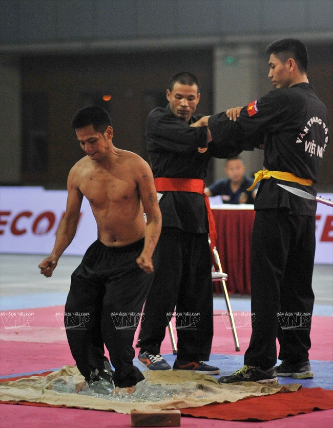 Nhảy chân trần vào đống mảnh chai sắc nhọn. (Ảnh: Trần Thanh Giang/Báo ảnh Việt Nam)