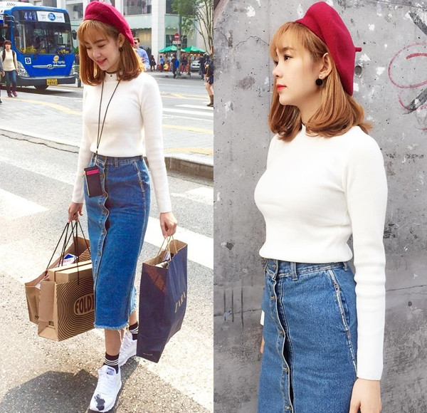 Minh Hằng hóa cô nàng cổ điển trên đường phố Seoul, Hàn Quốc. Cô mix áo thun trắng với chân váy bút chì denim, phối cùng mũ nồi mang cảm hứng retro và tạo điểm nhấn bằng đôi sneakers khỏe khoắn.