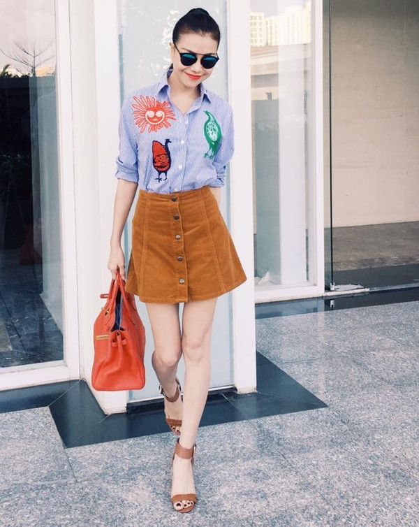 Trà Ngọc Hằng ghi điểm với bộ cánh dạo phố cuối tuần qua. Người đẹp phối sơmi họa tiết vui nhộn cùng chân váy mini duyên dáng. Sandals cao gót tiệp màu với chân váy cũng giúp tăng vẻ điệu đà, lôi cuốn.