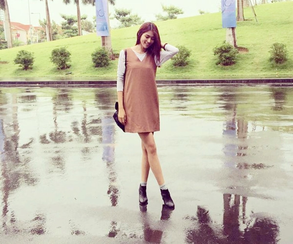 Chế Nguyễn Quỳnh Châu thích thú với tiết trời Hà Nội sau cơn mưa. Chân dài tài năng mix áo thun đơn giản cùng đầm suông cổ điển, chấm phá bằng đôi boots da mạnh mẽ. 