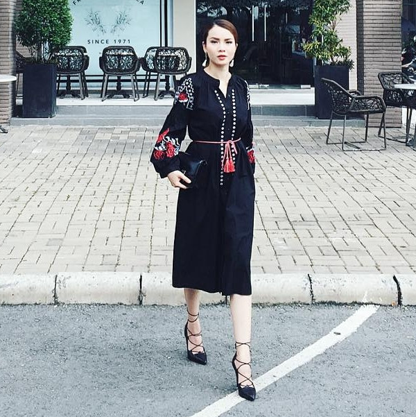 Yến Trang thời thượng cùng đầm đen thêu hoa mang cảm hứng du mục cổ điển. Đôi giày cao gót buộc dây (lace up heels) được nữ ca sỹ chọn làm điểm nhấn, tôn lên nét đẹp cổ điển.