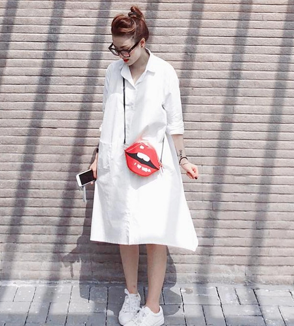 Yến Nhi chọn đầm sơmi trắng và giày thể thao yêu thích cho buổi dạo phố. Cô cũng không quên nhấn nhá cá tính bằng túi đeo hình đôi môi lạ mắt làm tăng vẻ năng động, tinh nghịch.