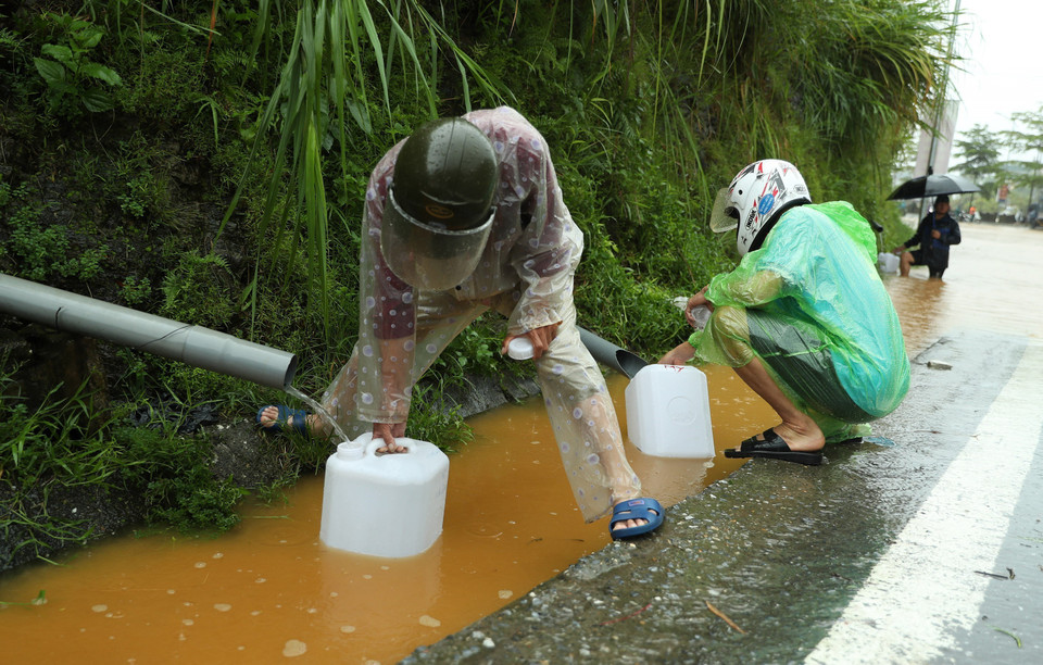 Rất đông người dân thành phố Lào Cai xếp hàng chờ đến lượt để hững những giọt nước từ thiên nhiên. (Ảnh: Quốc Khánh/TTXVN)