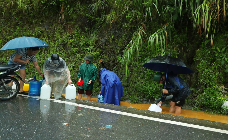 Mưa mỗi lúc một to, nhưng người dân thành phố Lào Cai vẫn kiên trì hứng nước. (Ảnh: Quốc Khánh/TTXVN)