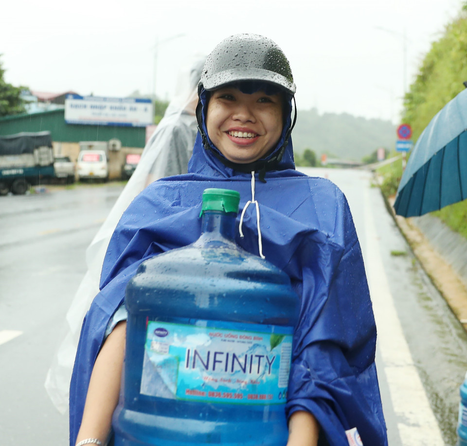 Niềm hạnh phúc của một người phụ nữ khi đã lấy đầy được bình 20 lít để có nước chuẩn bị bữa cơm chiều. (Ảnh: Quốc Khánh/TTXVN)