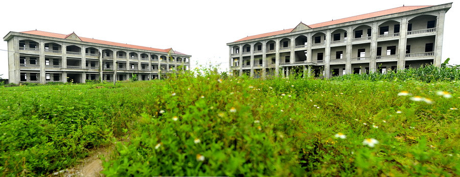 Trường trung học phổ thông Vũ Duy Thanh hiện vẫn phải nằm ​'đắp chiếu' giữa muôn trùng cỏ cây. (Ảnh: Minh Đức/TTXVN)