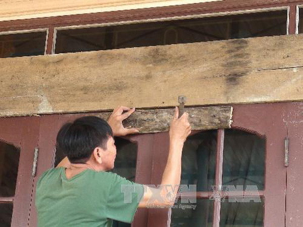 Người dân Đồng Hới, Quảng Bình chằng, chống nhà cửa. (Ảnh: Võ Dung/TTXVN)