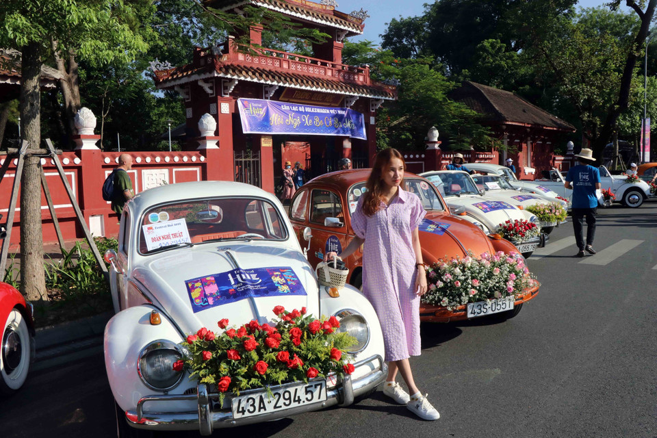 Du khách ghi lại khoảnh khắc đẹp bên những chiếc xe ôtô cổ. (Ảnh: Đỗ Trưởng/TTXVN)