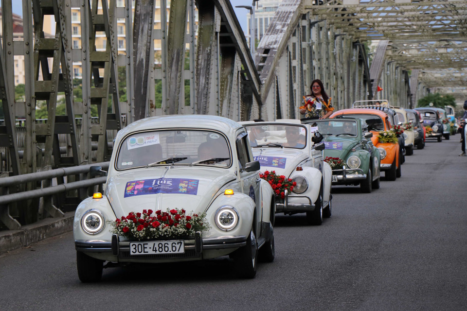 Diễu hành xe ôtô cổ qua cầu Trường Tiền. (Ảnh: Đỗ Trưởng/TTXVN)