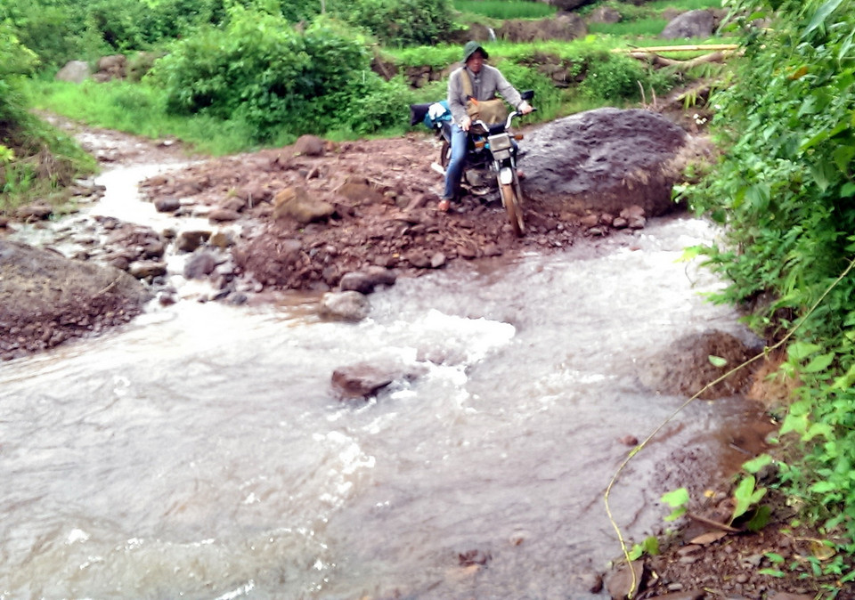 Phía trước bản, dòng suối Nậm Cuổi suốt ngày gầm réo, nhất là những ngày mưa này, nước từ thượng nguồn đổ về đỏ ngầu. (Ảnh: Hải Sơn/Vietnam+)