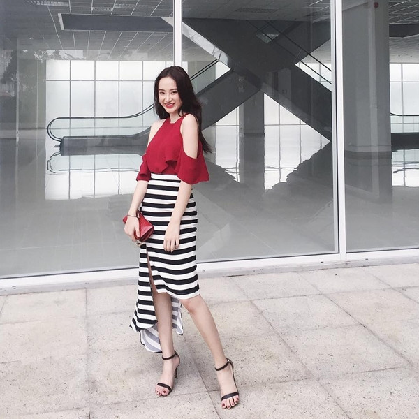 Angela Phương Trinh khoe vai trắng ngần với mẫu áo cut-out màu đỏ rực rỡ. Cô giáo Phong Linh của bộ phim 'Sứ mệnh trái tim' kết hợp thiết kế bắt mắt này cùng chân váy kẻ, có vạt bất đối xứng, càng tôn lên vẻ nữ tính, tinh tế.