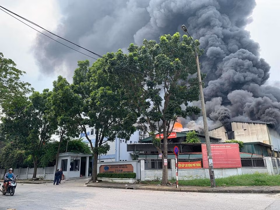 Cột khói cao hàng chục mét bốc lên từ một khu kho xưởng nằm trong Khu Công nghiệp kèm theo đó là lửa rất lớn. (Ảnh: PV/Vietnam+)