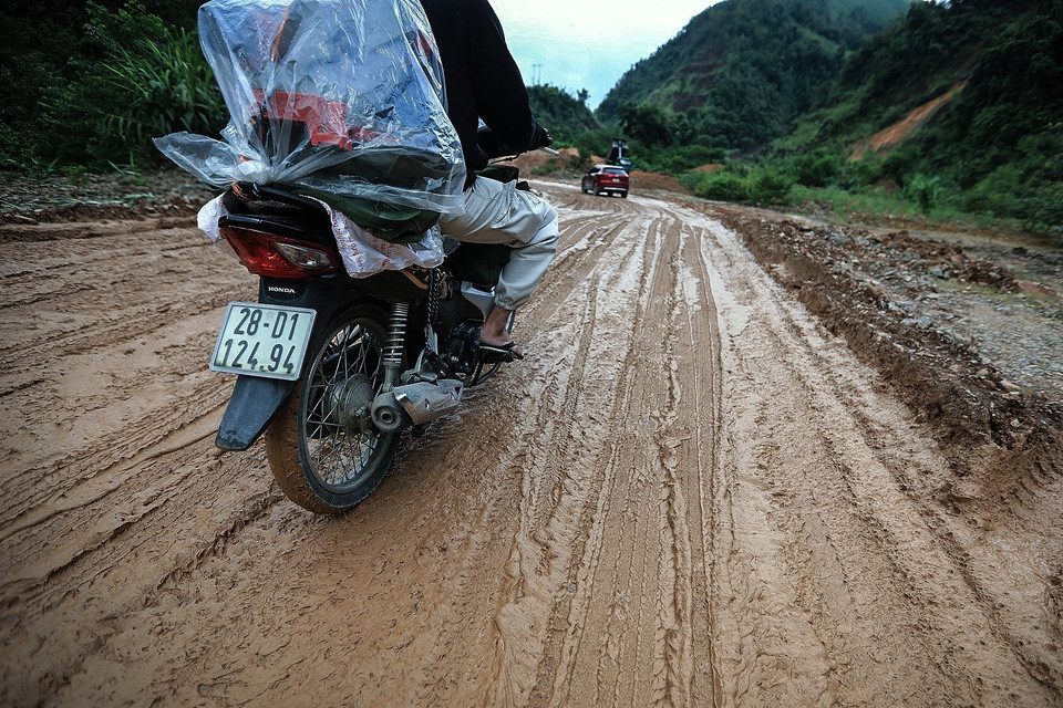 Người dân di chuyển khó khăn trên con đường đầy bùn trơn trượt khi lưu thông qua các điển sạt lở trên tuyến đường tỉnh 433 từ thành phố Hòa Bình đi huyện vùng cao Đà Bắc. (Ảnh: Trọng Đạt/TTXVN)