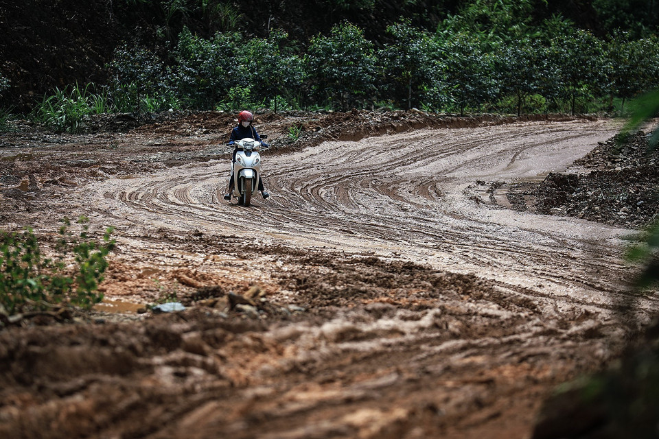 Người dân di chuyển khó khăn trên con đường đầy bùn trơn trượt khi lưu thông qua các điển sạt lở trên tuyến đường tỉnh 433 từ thành phố Hòa Bình đi huyện vùng cao Đà Bắc. (Ảnh: Trọng Đạt/TTXVN)