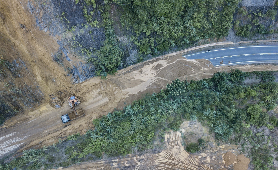 Lực lượng chức năng của Sở Giao thông vận tải đang khẩn trương khắc phục, sửa chữa, dọn dẹp đất đá thông tuyến. (Ảnh: Trọng Đạt/TTXVN)