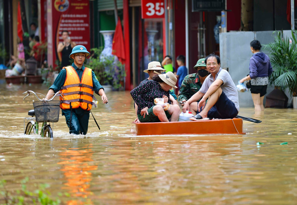 Lực lượng quân đội, Công an, dân quân giúp dân xã Bát Tràng, huyện Gia Lâm (Hà Nội) di chuyển ra khỏi vùng ngập lụt. (Ảnh: Thanh Tùng/TTXVN)