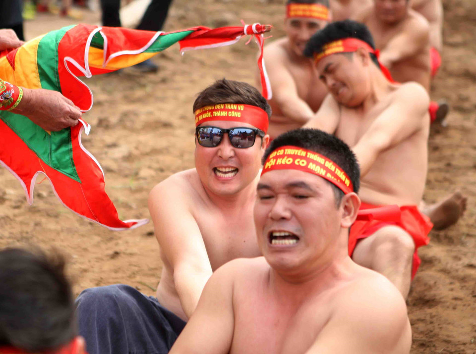 Một “trai kéo” tới từ Hàn Quốc (người đeo kính) cùng tham gia kéo. (Ảnh: Thanh Tùng/TTXVN)