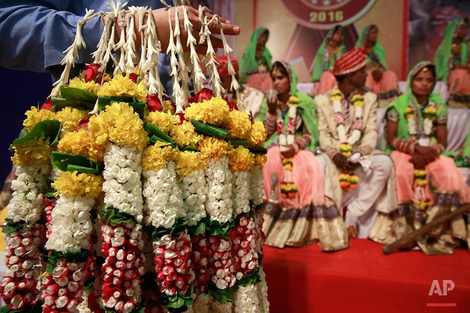 Các tình nguyện viên tổ chức đám cưới tập thể mang tặng vòng hoa cho các cặp vợ chồng. (Nguồn: AP)