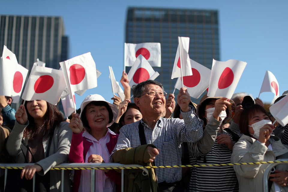 Người dân Nhật Bản vẫy cờ chào đón Nhật hoàng Naruhito và Hoàng hậu Masako tại lễ diễu hành ở Tokyo, Nhật Bản, ngày 10/11/2019. (Nguồn: AFP/TTXVN)