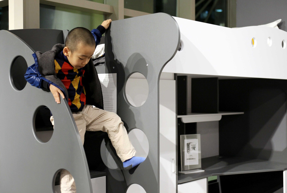 Cậu bé này khá nhí nhảnh khi trèo lên trèo xuống để ‘thử sản phẩm’. (Ảnh: Doãn Đức/Vietnam+)