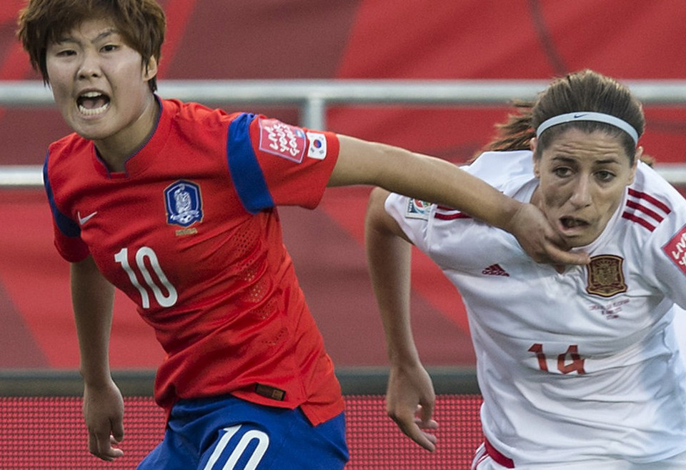 Nữ cầu thủ Tây Ban Nha (phải) và nữ cầu thủ Hàn Quốc Kim Ji Sohyun (trái) tranh chấp trong trận đấu thuộc bảng E của World Cup bóng đá nữ 2015. (Nguồn: Sputnik)
