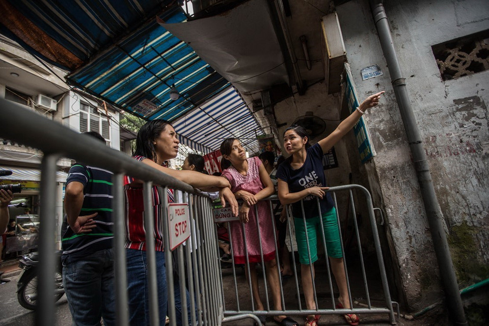 Nhiều người chỉ biết đứng ngoài khi khu vực cháy vẫn đang bị cấm vào. (Ảnh: Trọng Đạt/TTXVN)