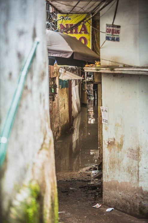 Con ngõ nhỏ dẫn vào xóm trọ Nhân Ái sau vụ hỏa hoạn vẫn ngập đầy nước và bị niêm phong để phục vụ công tác điều tra. (Ảnh: Trọng Đạt/TTXVN)