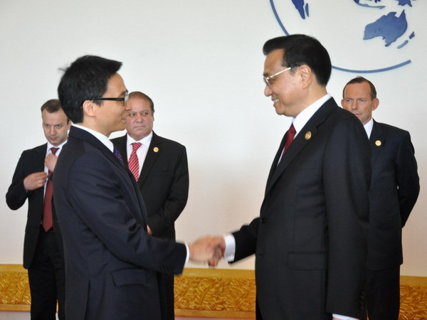 Thủ tướng Trung Quốc Lý Khắc Cường (bên phải) đón Phó Thủ tướng Vũ Đức Đam đến dự diễn đàn.(Ảnh: Hải Yến/TTXVN)