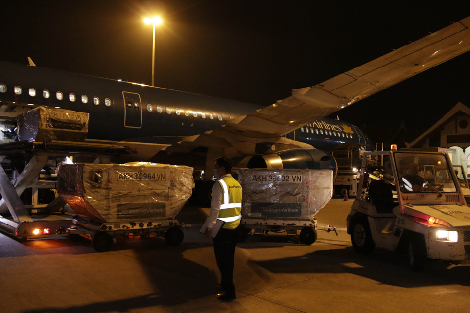 Những thùng hàng viện trợ đầu tiên được dỡ xuống sau khi chuyên cơ của Vietnam Airlines vận chuyển an toàn tới Sân bay quốc tế Wattay ở thủ đô Vientiane vào lúc 0 giờ 10 phút sáng 4/4. (Ảnh: Phạm Kiên/Vietnam+)