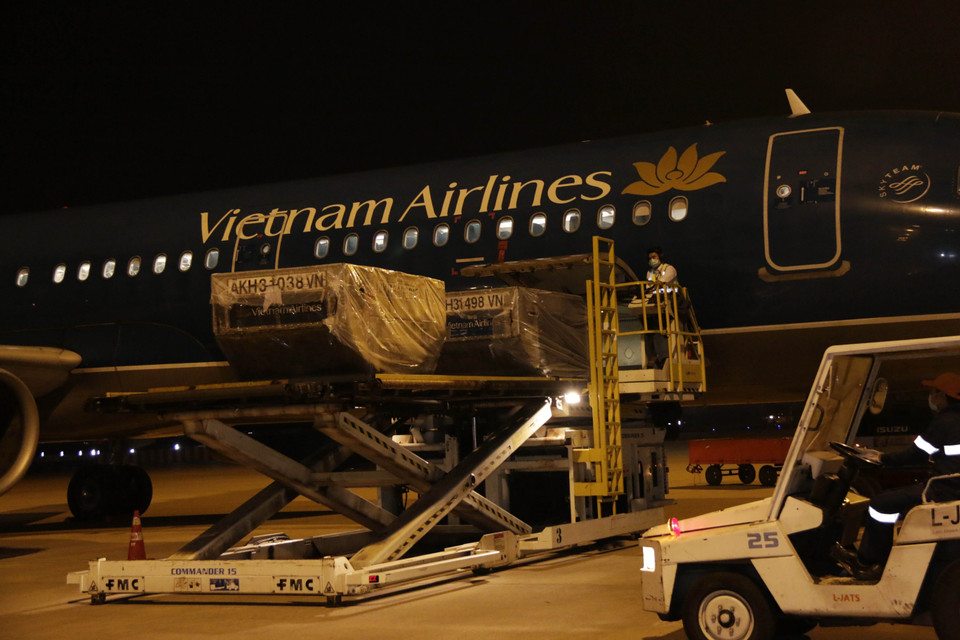 Những thùng hàng viện trợ đầu tiên được dỡ xuống sau khi chuyên cơ của Vietnam Airlines vận chuyển an toàn tới Sân bay quốc tế Wattay ở thủ đô Vientiane vào lúc 0 giờ 10 phút sáng 4/4. (Ảnh: Phạm Kiên/Vietnam+)