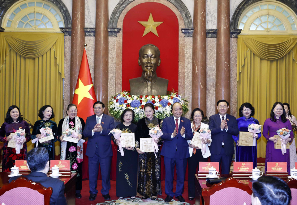 Chủ tịch nước Nguyễn Xuân Phúc, Thủ tướng Chính phủ Phạm Minh Chính, Chủ tịch Quốc hội Vương Đình Huệ tặng hoa cho các nữ đại biểu. (Ảnh: Thống Nhất/TTXVN)