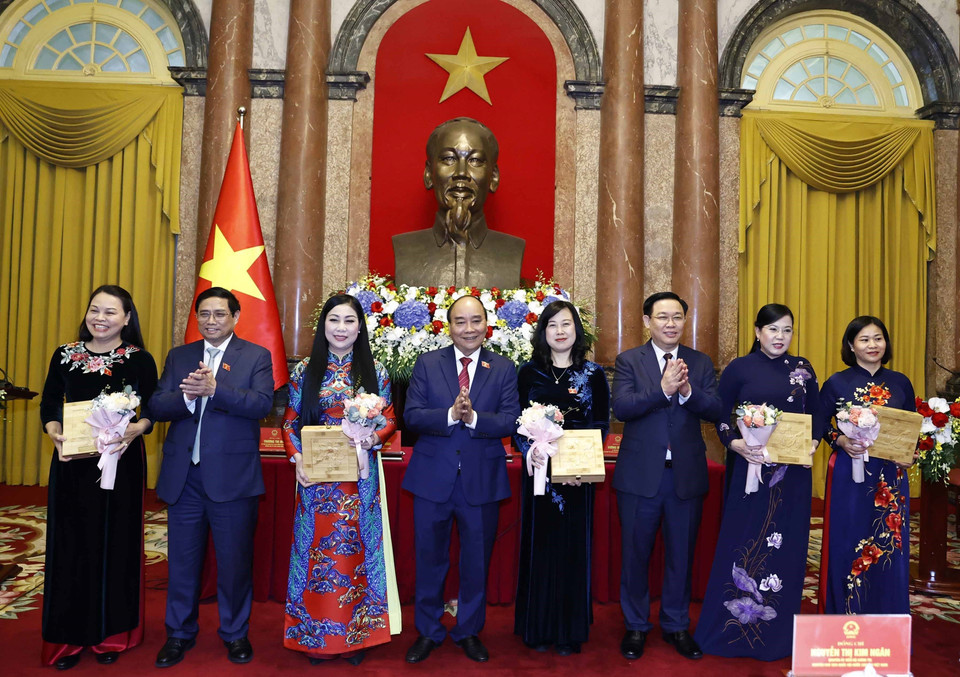 Chủ tịch nước Nguyễn Xuân Phúc, Thủ tướng Chính phủ Phạm Minh Chính, Chủ tịch Quốc hội Vương Đình Huệ tặng hoa cho các nữ đại biểu. (Ảnh: Thống Nhất/TTXVN)