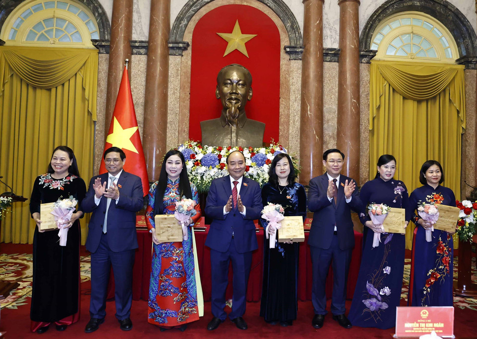 Chủ tịch nước Nguyễn Xuân Phúc, Thủ tướng Chính phủ Phạm Minh Chính, Chủ tịch Quốc hội Vương Đình Huệ tặng hoa cho các nữ đại biểu, chiều 20/10/2022. (Ảnh: Thống Nhất/TTXVN)