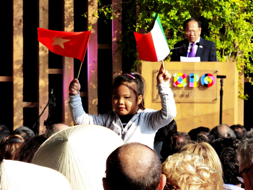 Một em nhỏ cầm hai lá cờ Việt Nam-Italy. (Ảnh: Quang Thanh/Vietnam+)