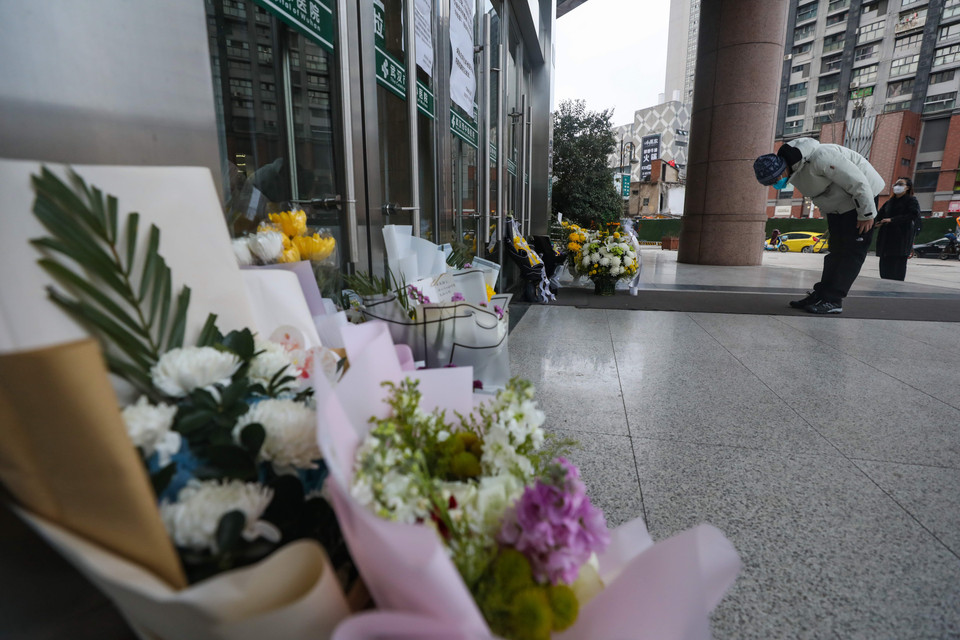 Một người đàn ông cúi người tưởng nhớ bác sỹ Lý Văn Lượng trước cửa bệnh viện trung tâm Vũ Hán. (Nguồn: Getty Images)