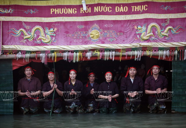 Kết thúc chương trình, tấm màn ngăn cách người nghệ sỹ và khán giả cùng những con rối được kéo lên và khi đó người xem mới được nhìn thấy những con người tài hoa của làng rối Đào Thục. (Ảnh: Trần Thanh Giang/Báo ảnh Việt Nam)