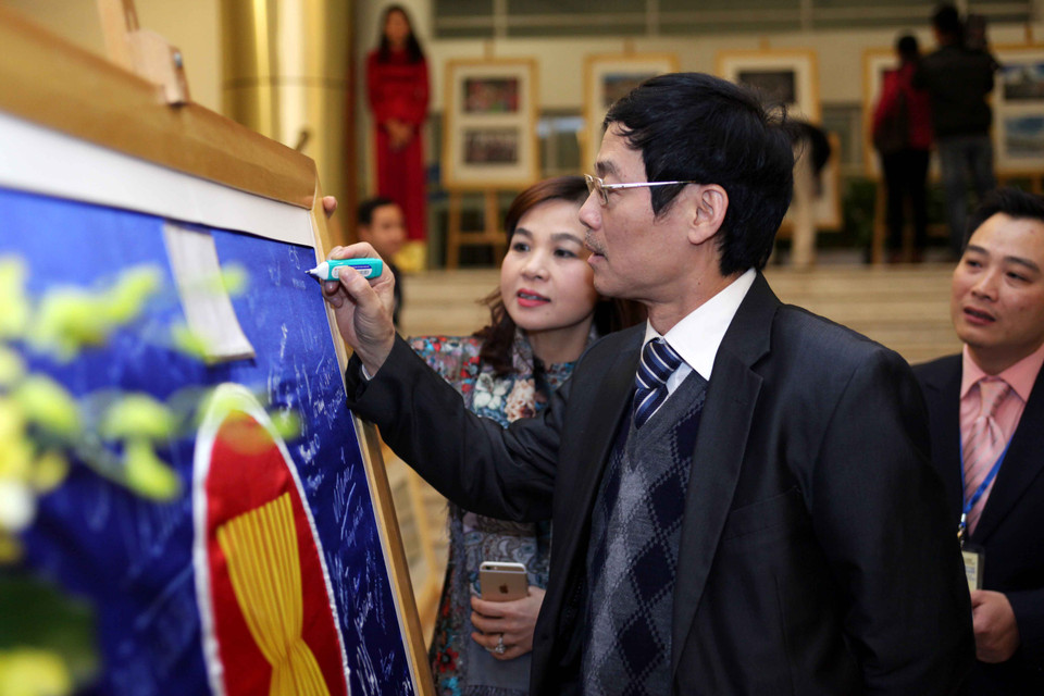 Các đại biểu ký tên lên tấm hình biểu tượng của ‘Ngôi nhà chung ASEAN’. (Ảnh: Doãn Đức/Vietnam+)