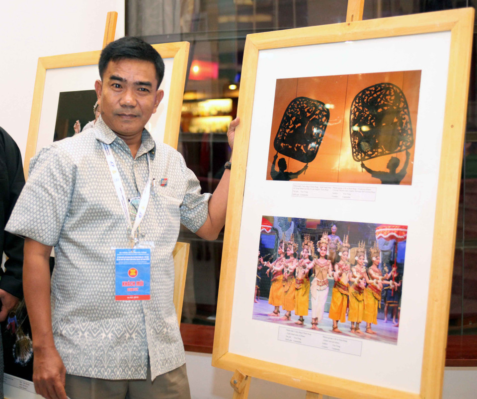 Một trong các tác giả tham gia liên hoan chụp ảnh lưu niệm với tác phẩm của mình. (Ảnh: Doãn Đức/Vietnam+)