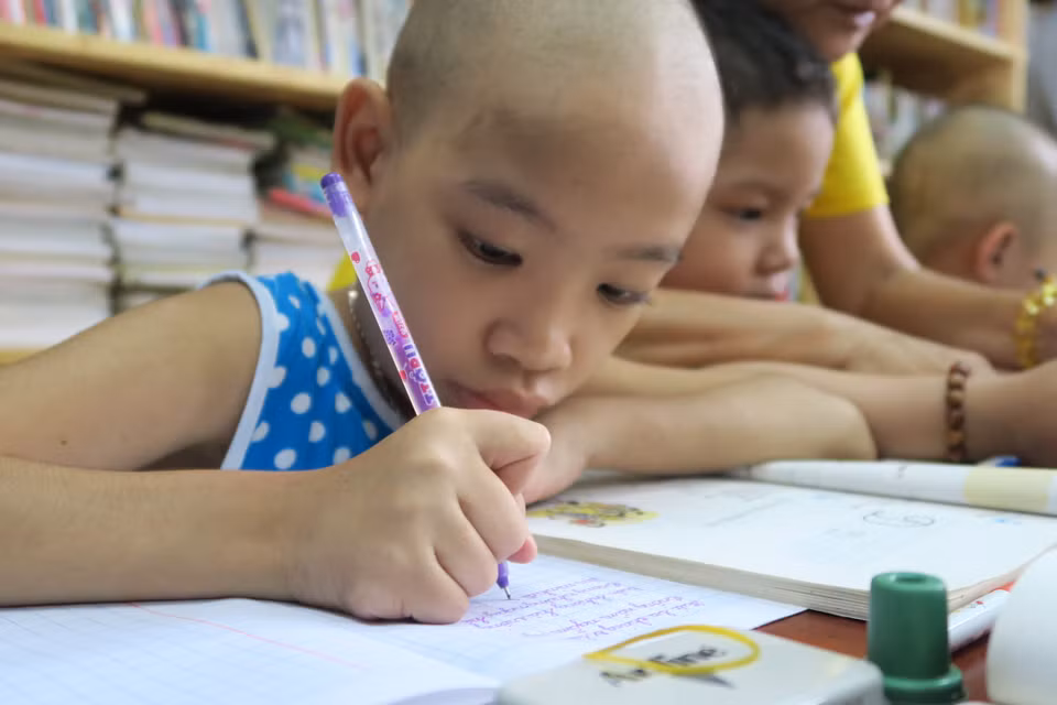 Bệnh nhi ung thư miệt mài với từng con chữ. (Ảnh: Đinh Hằng/TTXVN)