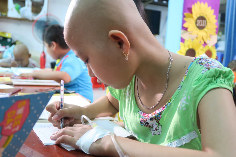 Bệnh nhi ung thư miệt mài với từng con chữ. (Ảnh: Đinh Hằng/TTXVN)