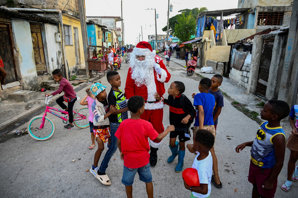 Ông già Noel phát quà cho các em nhỏ trên đường phố ở La Habana (Cuba), ngày 21/12/2023. (Ảnh: AFP/TTXVN)