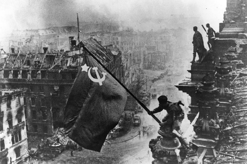 Một người lính Hồng quân cắm cờ trên nóc tòa nhà Quốc hội Đức ở Berlin ngày 30/4/1945 (Nguồn: Getty)